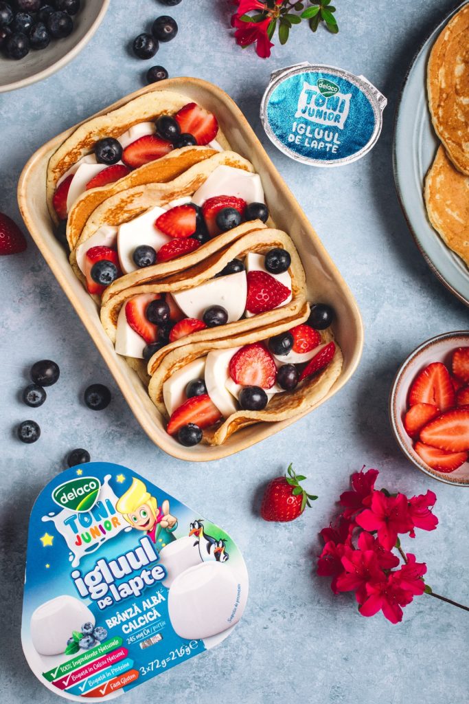 Pancake tacos pentru copii cu brânză calcică, căpșuni și afine, prezentare colorată pentru micul dejun.